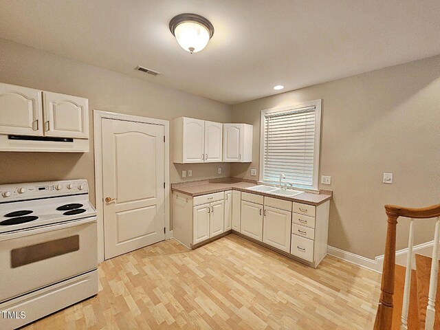 kitchen featuring white range with electric cooktop, sink, white cabinets, and light hardwood / wood-style floors