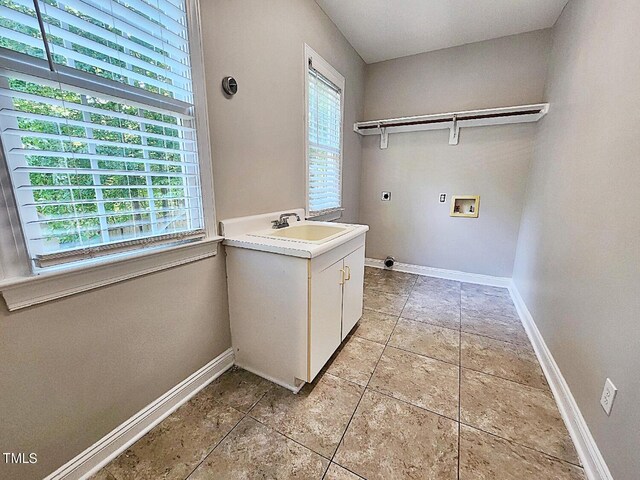 clothes washing area featuring light tile patterned floors, a wealth of natural light, electric dryer hookup, and hookup for a washing machine