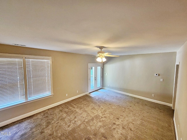 spare room featuring carpet flooring, ceiling fan, and french doors