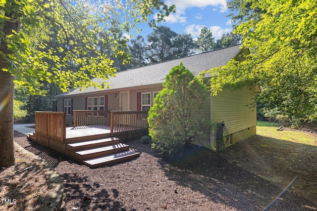 rear view of property featuring a wooden deck