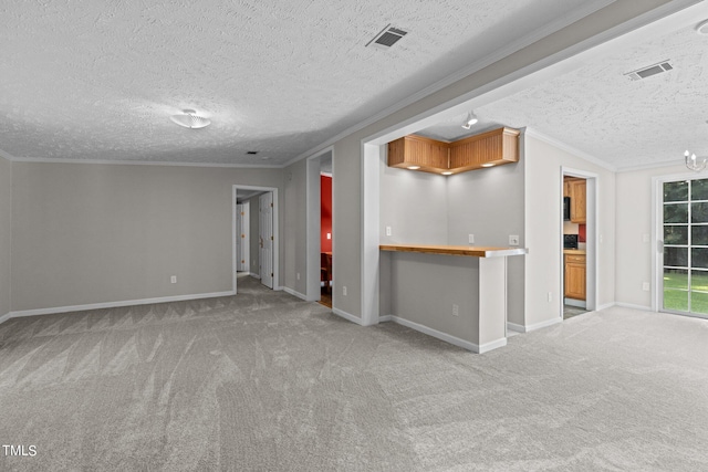 unfurnished living room with carpet, crown molding, and a textured ceiling