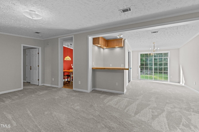 carpeted empty room featuring ornamental molding, a notable chandelier, and a textured ceiling