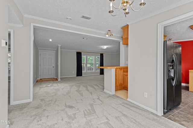 interior space featuring black fridge, ornamental molding, carpet, and a textured ceiling