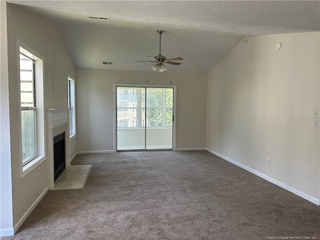 unfurnished living room with a textured ceiling, carpet flooring, vaulted ceiling, and ceiling fan