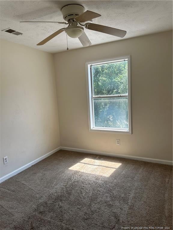 empty room with a textured ceiling, ceiling fan, and carpet floors