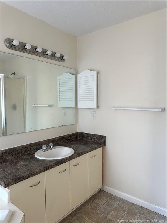 bathroom featuring vanity, an enclosed shower, and tile patterned flooring