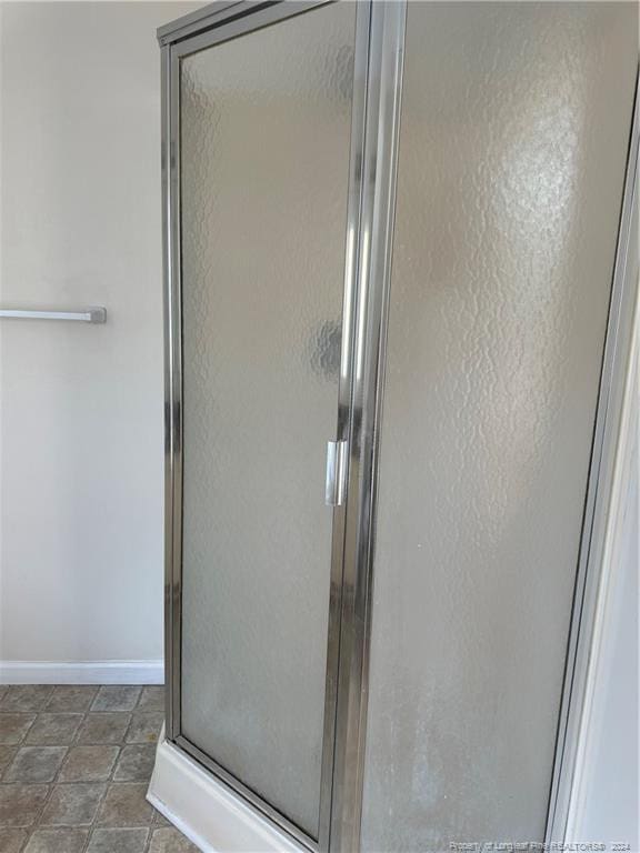 bathroom featuring tile patterned flooring and a shower with shower door