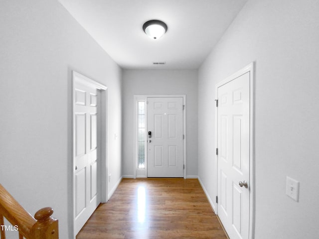 foyer entrance featuring baseboards and wood finished floors