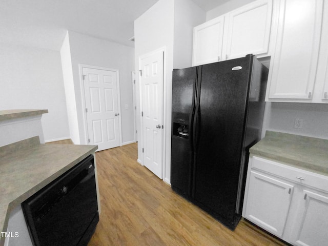 kitchen with light wood-style floors, light countertops, white cabinets, and black appliances