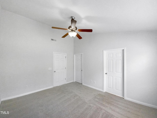 unfurnished bedroom with high vaulted ceiling, light colored carpet, a ceiling fan, baseboards, and visible vents