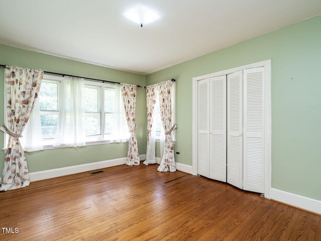 unfurnished bedroom featuring wood-type flooring and a closet