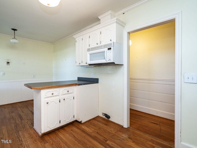 kitchen featuring dark wood-type flooring, white cabinetry, kitchen peninsula, and crown molding