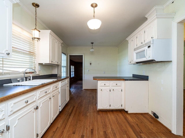 kitchen with white cabinetry, sink, hanging light fixtures, and dark hardwood / wood-style floors