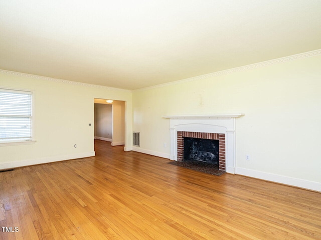 unfurnished living room with ornamental molding, a fireplace, and hardwood / wood-style floors