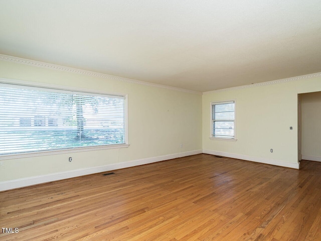 spare room with crown molding and hardwood / wood-style flooring