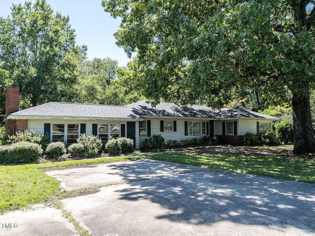 ranch-style home featuring a front lawn