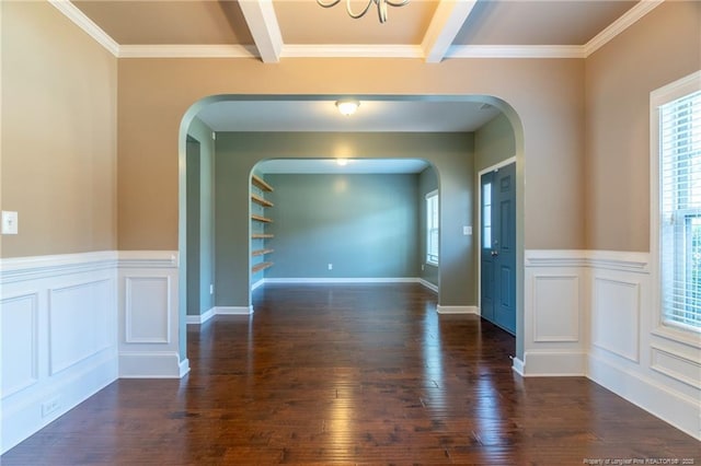 unfurnished room featuring dark hardwood / wood-style floors, ornamental molding, and beam ceiling