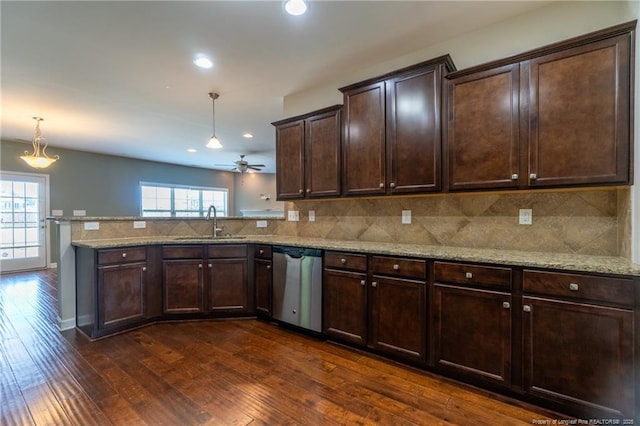 kitchen featuring sink, backsplash, hanging light fixtures, stainless steel dishwasher, and kitchen peninsula