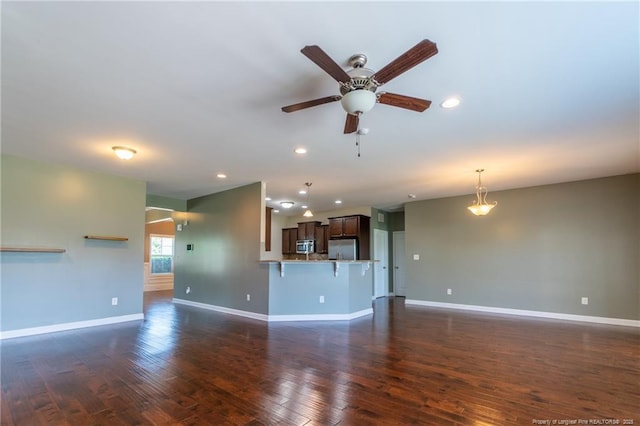 unfurnished living room with ceiling fan and dark hardwood / wood-style flooring