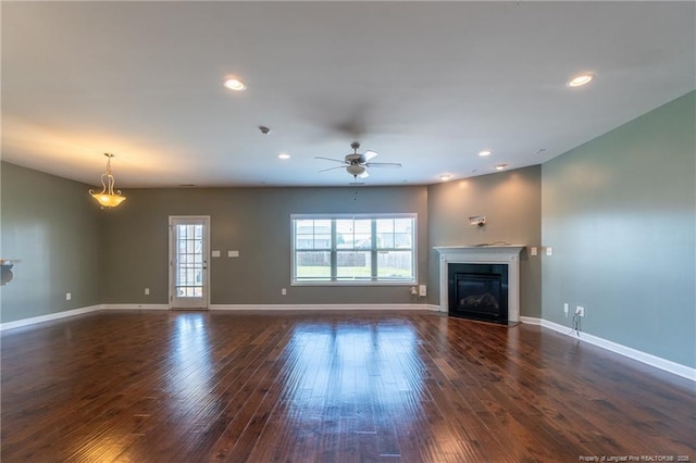 unfurnished living room with ceiling fan and dark hardwood / wood-style flooring