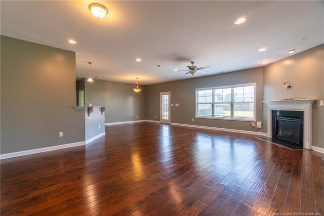 unfurnished living room with dark wood-type flooring and ceiling fan