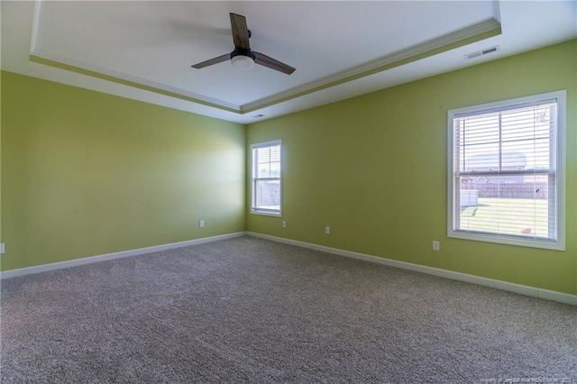 unfurnished room with ornamental molding, a raised ceiling, ceiling fan, and carpet flooring