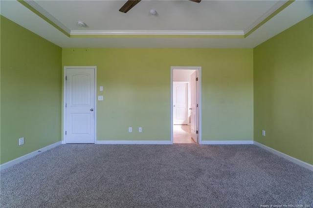 carpeted spare room with ornamental molding, ceiling fan, and a tray ceiling