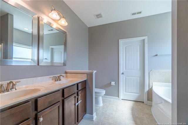 bathroom with vanity, a bathtub, and toilet