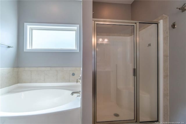 bathroom featuring shower with separate bathtub