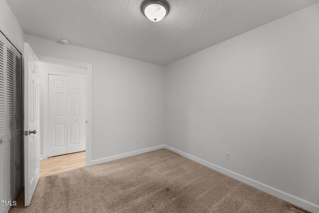 spare room featuring carpet and a textured ceiling