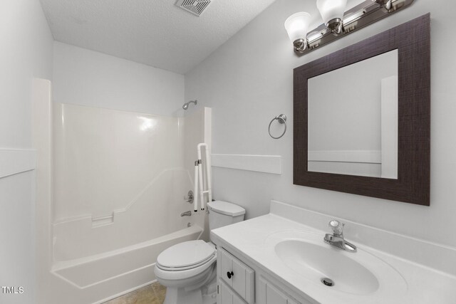 full bathroom with washtub / shower combination, tile patterned flooring, a textured ceiling, toilet, and vanity