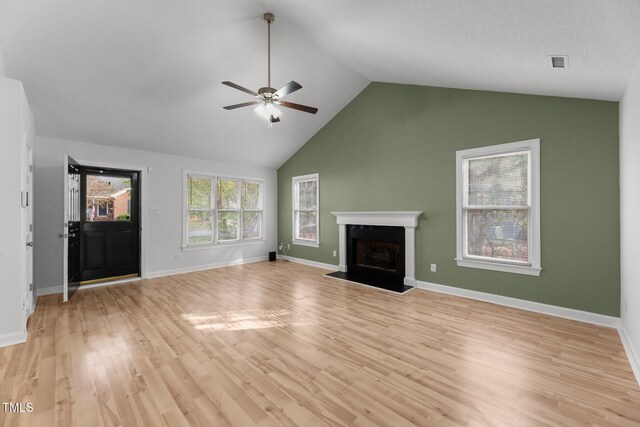 unfurnished living room with ceiling fan, vaulted ceiling, and light wood-type flooring