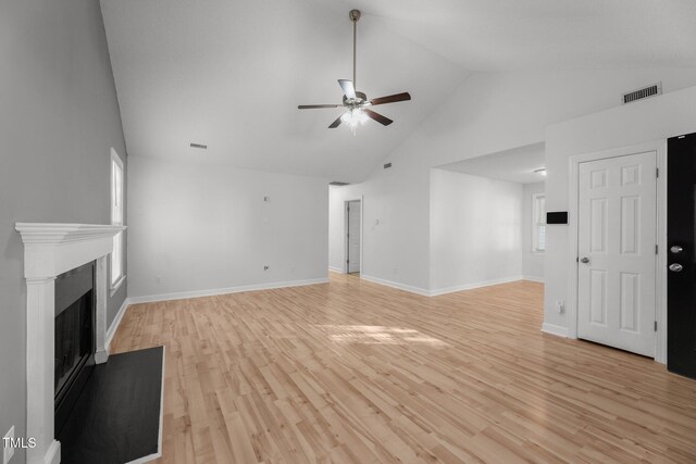 unfurnished living room featuring light hardwood / wood-style floors, high vaulted ceiling, and ceiling fan