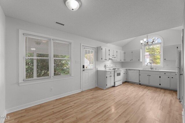 kitchen with light wood-type flooring, white appliances, sink, an inviting chandelier, and lofted ceiling