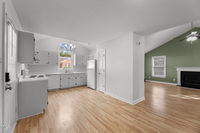 kitchen with lofted ceiling, light hardwood / wood-style floors, and white appliances