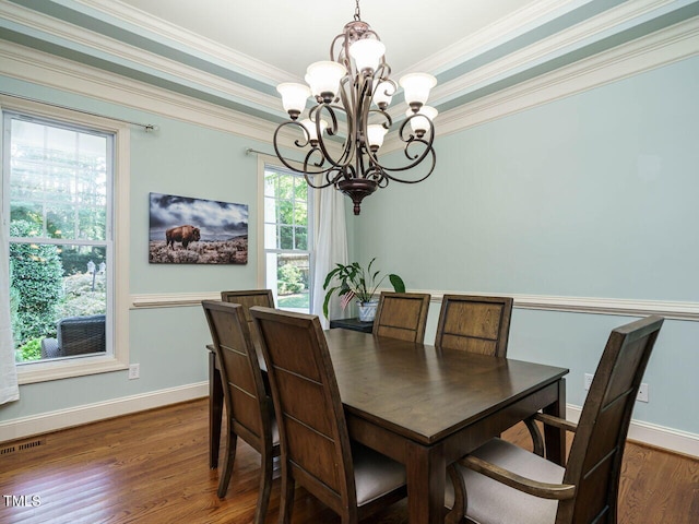 dining space with dark hardwood / wood-style flooring, a chandelier, and crown molding