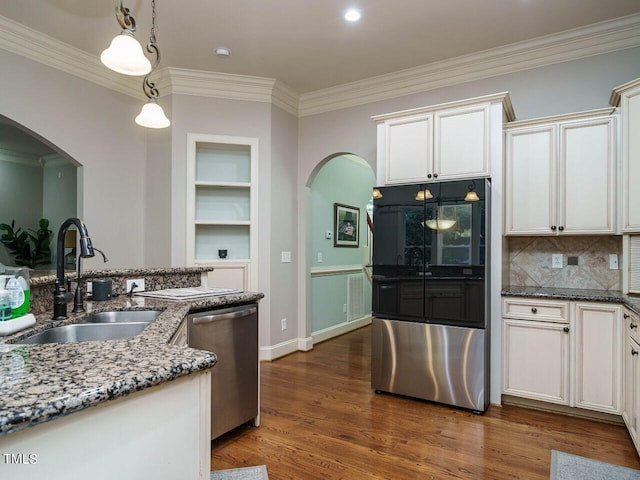 kitchen featuring dark hardwood / wood-style flooring, crown molding, stainless steel appliances, sink, and stone counters