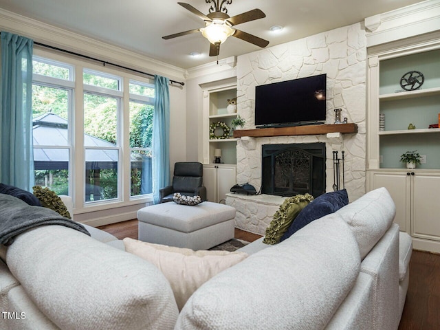 living room with built in shelves, dark wood-type flooring, ceiling fan, and a fireplace