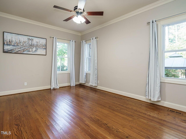 spare room with crown molding, dark wood-type flooring, a healthy amount of sunlight, and ceiling fan