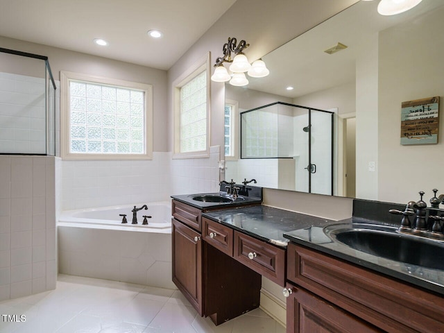 bathroom with tile patterned flooring, independent shower and bath, and vanity