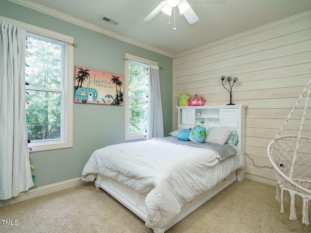 bedroom featuring crown molding, wood walls, ceiling fan, and carpet flooring