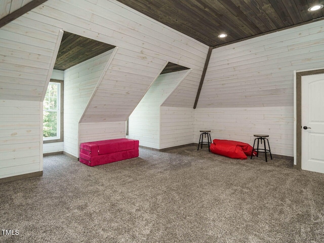 bonus room featuring lofted ceiling, wood walls, and wooden ceiling