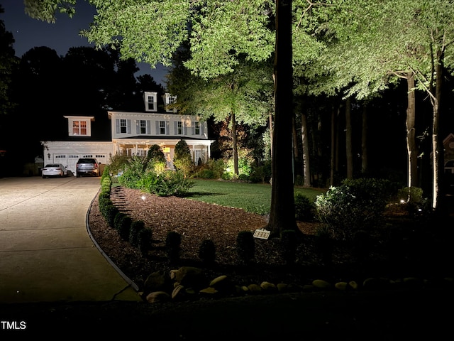 view of front of home with a garage and a lawn