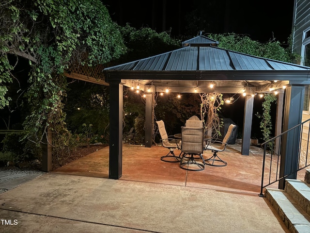 patio at night featuring a gazebo