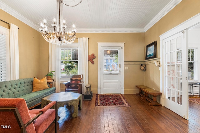 foyer entrance featuring an inviting chandelier, crown molding, and dark hardwood / wood-style flooring