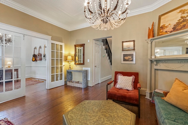 living area featuring ornamental molding, dark hardwood / wood-style floors, a chandelier, and french doors