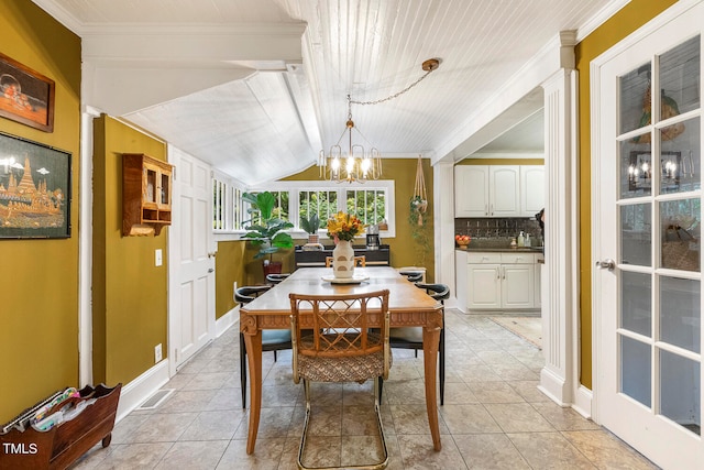 dining room with vaulted ceiling with beams, light tile patterned floors, crown molding, and a chandelier