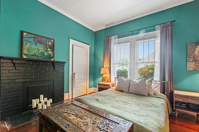 bedroom featuring a fireplace, dark hardwood / wood-style floors, and ornamental molding