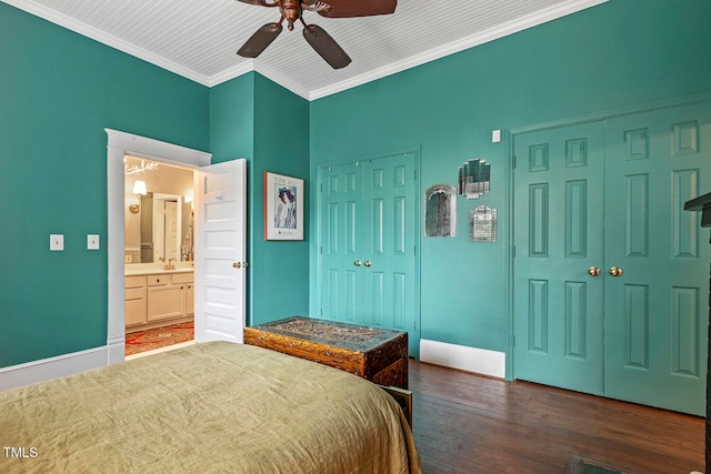 bedroom with crown molding, ceiling fan, ensuite bathroom, dark hardwood / wood-style floors, and two closets