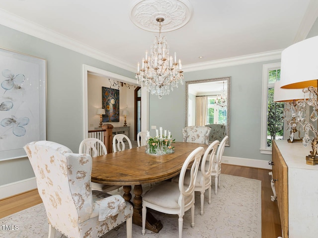 dining area featuring ornamental molding, a notable chandelier, and light hardwood / wood-style floors